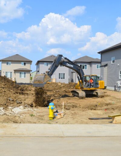 A Backhoe filling in a trench that had utility lines installed for a new home