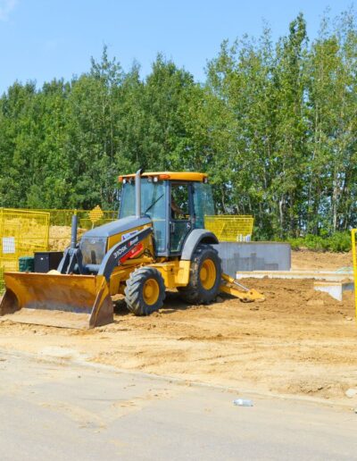 a backhoe working on a new home basement so utility lines can be hooked up